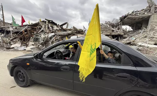 FILE - A boy holds a Hezbollah flag following a ceasefire between Israel and Hezbollah on Nov. 28, 2024, in Nabatiyeh, southern Lebanon. (AP Photo/Bassam Hatoum, File)