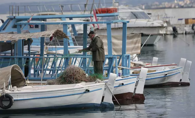 FILE - A fisherman prepares his nets at the port in Tyre, southern Lebanon on Nov. 29, 2024. (AP Photo/Hussein Malla, File)