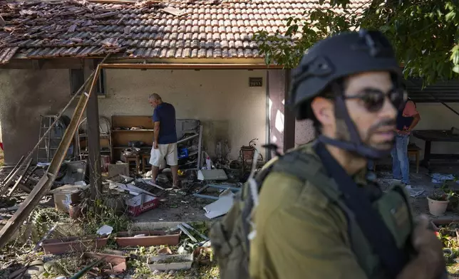 FILE - Israeli security forces and residents examine a house that was hit by a rocket fired from Lebanon, in Kibbutz Saar, northern Israel, on Wednesday, Sept. 25, 2024. (AP Photo/Baz Ratner, File)