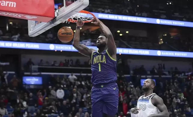 New Orleans Pelicans forward Zion Williamson (1) slam dunks ahead of Minnesota Timberwolves forward Julius Randle (30) in the second half of an NBA basketball game in New Orleans, Tuesday, Jan. 7, 2025. (AP Photo/Gerald Herbert)