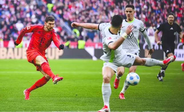 Munich's Leon Goretzka, left, scores scores the opening goal during the German Bundesliga soccer match between FC Bayern Munich and VfL Wolfsburg in Munich, Germany, Saturday, Jan. 18, 2025. (Tom Weller/dpa via AP)