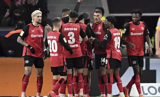 Leverkusen's players celebrate their side's opening goal during the German Bundesliga soccer match between Bayer Leverkusen and Borussia Moenchengladbach, at the BayArena in Leverkusen, Germany, Saturday, Jan. 18, 2025. (Federico Gambarini/dpa via AP)