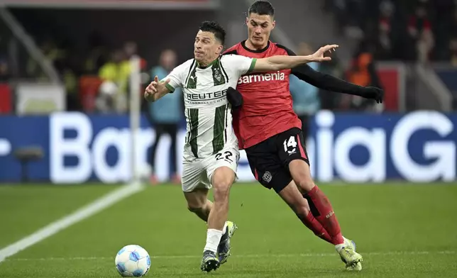 Leverkusen's Patrik Schick, right, and Gladbach's Stefan Lainer fight for the ball. during the German Bundesliga soccer match between Bayer Leverkusen and Borussia Moenchengladbach, at the BayArena in Leverkusen, Germany, Saturday, Jan. 18, 2025. (Federico Gambarini/dpa via AP)