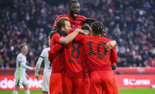 Munich's Leon Goretzka (center) celebrates with Dayot Upamecano (left) and teammates after scoring during the German Bundesliga soccer match between FC Bayern Munich and VfL Wolfsburg in Munich, Germany, Saturday, Jan. 18, 2025. (Tom Weller/dpa via AP)