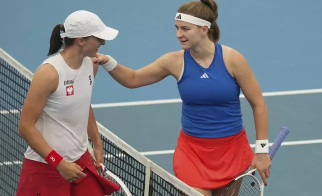 Poland's Iga Swiatek, left, is congratulated by Czech Republic's Karolina Muchova following their match at the United Cup tennis tournament in Sydney, Australia, Wednesday, Jan. 1, 2025. (AP Photo/Mark Baker)