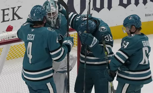 San Jose Sharks goaltender Yaroslav Askarov, second from left, celebrates with defenseman Cody Ceci (4), defenseman Mario Ferraro (38) and center Mikael Granlund after an NHL hockey game against the New Jersey Devils in San Jose, Calif., Saturday, Jan. 4, 2025. (AP Photo/Jeff Chiu)