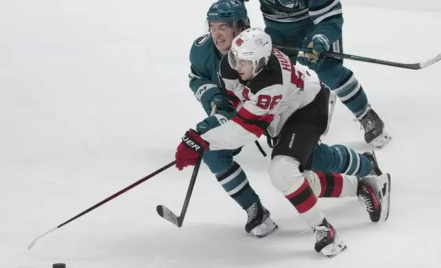 New Jersey Devils center Jack Hughes, right, skates toward the against San Jose Sharks center Macklin Celebrini during the third period of an NHL hockey game in San Jose, Calif., Saturday, Jan. 4, 2025. (AP Photo/Jeff Chiu)