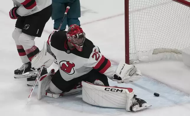 New Jersey Devils goaltender Jacob Markstrom (25) cannot stop a goal scored by San Jose Sharks defenseman Cody Ceci during the third period of an NHL hockey game in San Jose, Calif., Saturday, Jan. 4, 2025. (AP Photo/Jeff Chiu)