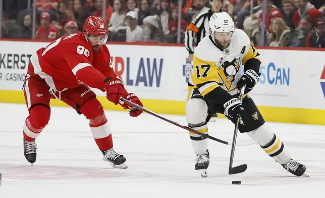 Pittsburgh Penguins right wing Bryan Rust (17) skater toward the goal past Detroit Red Wings center Joe Veleno (90) during the second period of an NHL hockey game Tuesday, Dec. 31, 2024, in Detroit. (AP Photo/Duane Burleson)