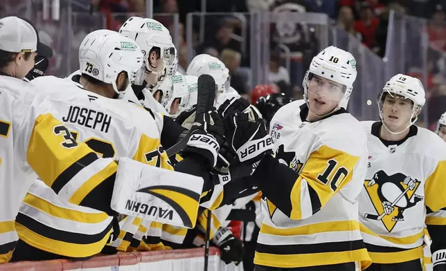 Pittsburgh Penguins left wing Drew O'Connor (10) celebrates his goal against the Detroit Red Wings with teammates during the first period of an NHL hockey game Tuesday, Dec. 31, 2024, in Detroit. (AP Photo/Duane Burleson)