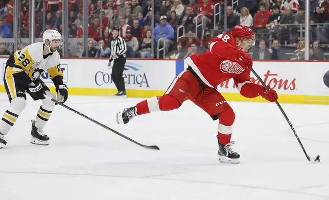 Detroit Red Wings right wing Jonatan Berggren (48) scores while being pursued by Pittsburgh Penguins defenseman Marcus Pettersson (28) during the first period of an NHL hockey game Tuesday, Dec. 31, 2024, in Detroit. (AP Photo/Duane Burleson)