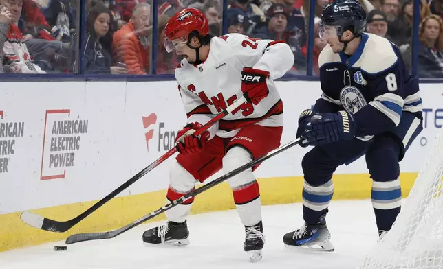 Carolina Hurricanes' Seth Jarvis, left, controls the puck in front of Columbus Blue Jackets' Zach Werenski, right, during the first period of an NHL hockey game Tuesday, Dec. 31, 2024, in Columbus, Ohio. (AP Photo/Jay LaPrete)