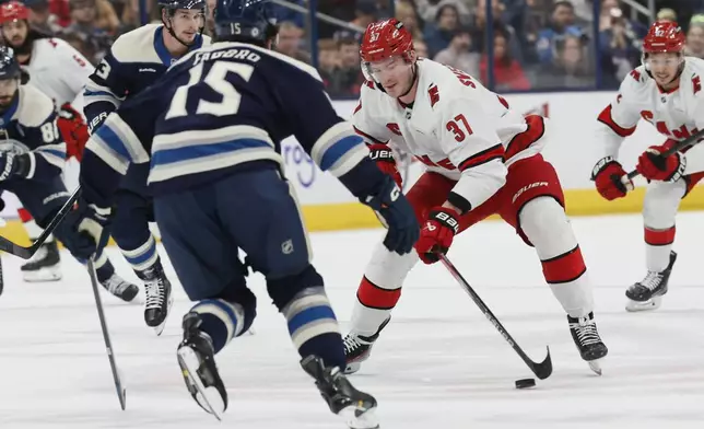 Carolina Hurricanes' Andrei Svechnikov, right, carries the puck across center ice as Columbus Blue Jackets' Dante Fabbro defends during the first period of an NHL hockey game Tuesday, Dec. 31, 2024, in Columbus, Ohio. (AP Photo/Jay LaPrete)