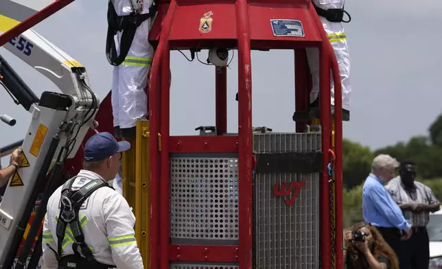 Mine rescue workers work on a cage that was used to rescue trapped miners at an abandoned gold mine, where miners were rescued from below ground, in Stilfontein, South Africa, Thursday, Jan. 16, 2025. (AP Photo/Themba Hadebe)