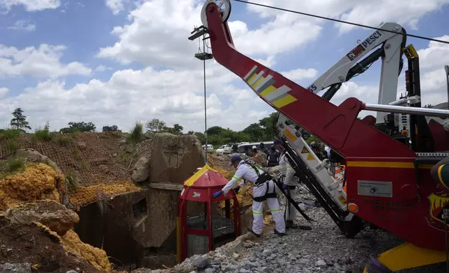 Mine rescue workers host up a cage that was used to rescue trapped miners at an abandoned gold mine, where miners were rescued from below ground, in Stilfontein, South Africa, Thursday, Jan. 16, 2025. (AP Photo/Themba Hadebe)