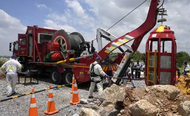 Mine rescue workers host up a cage that was used to rescue trapped miners at an abandoned gold mine, where miners were rescued from below ground, in Stilfontein, South Africa, Thursday, Jan. 16, 2025. (AP Photo/Themba Hadebe)