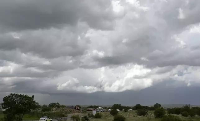 Rescue workers; motor vehicles park near a rescue operation for miners trapped below ground in an abandoned gold mine in Stilfontein, South Africa, Wednesday, Jan. 15, 2025. (AP Photo/Themba Hadebe)