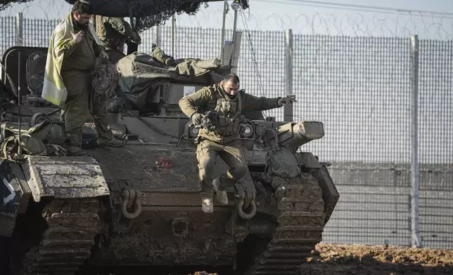 An Israeli soldier jumps off an armoured vehicle at a staging area near the Gaza border in southern Israel, Thursday Jan. 2, 2025. (AP Photo/Tsafrir Abayov))