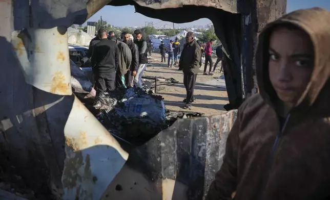 Palestinians inspect the site of an earlier Israeli army strike in the Muwasi area, in Khan Younis, central Gaza Strip, Thursday Jan. 2, 2025. According to Palestinian medical officials, the airstrike killed at least 10 people, including three children and two senior police officers, in an Israeli-designated humanitarian zone in the Gaza Strip. (AP Photo/Abdel Kareem Hana)