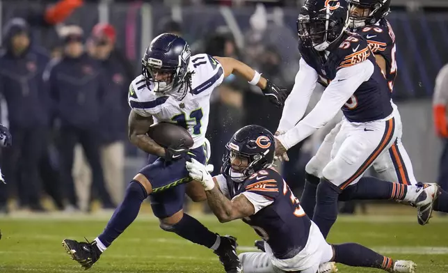 Seattle Seahawks wide receiver Jaxon Smith-Njigba (11) runs with the ball as Chicago Bears safety Jonathan Owens (36) and defensive end Jacob Martin (55) try to stop him during the second half of an NFL football game, Thursday, Dec. 26, 2024, in Chicago. (AP Photo/Erin Hooley)