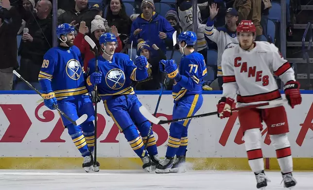 Buffalo Sabres center Ryan McLeod, second from left, celebrates with right wing Alex Tuch, left, and right wing JJ Peterka (77) after scoring during the first period of an NHL hockey game against the Carolina Hurricanes in Buffalo, N.Y., Wednesday, Jan. 15, 2025. (AP Photo/Adrian Kraus)