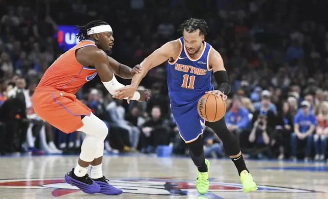 New York Kincks guard Jalen Brunson, right, drives past Oklahoma City Thunder guard Luguentz Dort, left, during the first half of an NBA basketball game, Friday, Jan 3, 2025, in Oklahoma City. (AP Photo/Kyle Phillips)