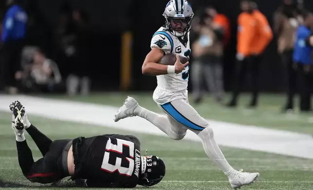 Carolina Panthers quarterback Bryce Young runs past Atlanta Falcons linebacker Nate Landman during the second half of an NFL football game, Sunday, Jan. 5, 2025, in Atlanta. (AP Photo/Mike Stewart)