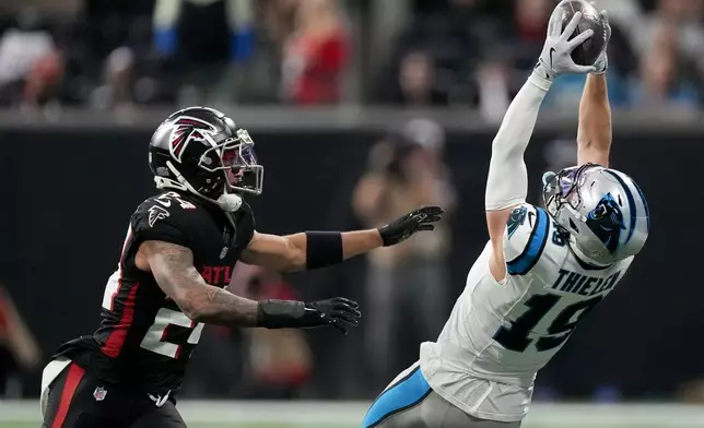 Carolina Panthers wide receiver Adam Thielen catches a pass in front of Atlanta Falcons cornerback A.J. Terrell during the first half of an NFL football game, Sunday, Jan. 5, 2025, in Atlanta. (AP Photo/Mike Stewart)