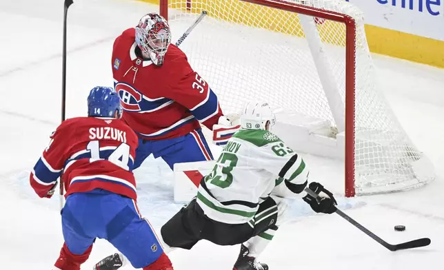 Dallas Stars' Evgenii Dadonov (63) moves in on Montreal Canadiens goaltender Sam Montembeault as Canadiens' Nick Suzuki (14) defends during first period NHL hockey action in Montreal, Saturday, January 11, 2025. (Graham Hughes/The Canadian Press via AP)