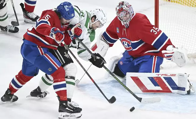 Dallas Stars' Sam Steel (18) moves in on Montreal Canadiens goaltender Sam Montembeault as Canadiens' Alex Newhook (15) defends during first period NHL hockey action in Montreal, Saturday, Jan. 11, 2025. (Graham Hughes/The Canadian Press via AP)