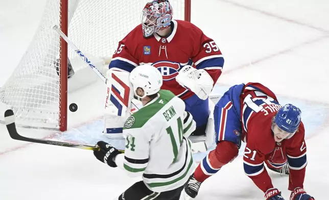 Dallas Stars' Jamie Benn (14) scores against Montreal Canadiens goaltender Sam Montembeault as Canadiens' Kaiden Guhle (21) defends during second period NHL hockey action in Montreal, Saturday, Jan. 11, 2025. (Graham Hughes/The Canadian Press via AP)