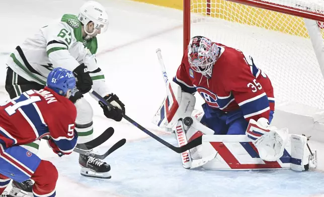 Dallas Stars' Evgenii Dadonov (63) moves in against Montreal Canadiens goaltender Sam Montembeault (35) as Canadiens' Emil Heineman (51) defends during third-period NHL hockey game action in Montreal, Saturday, Jan. 11, 2025. (Graham Hughes/The Canadian Press via AP)