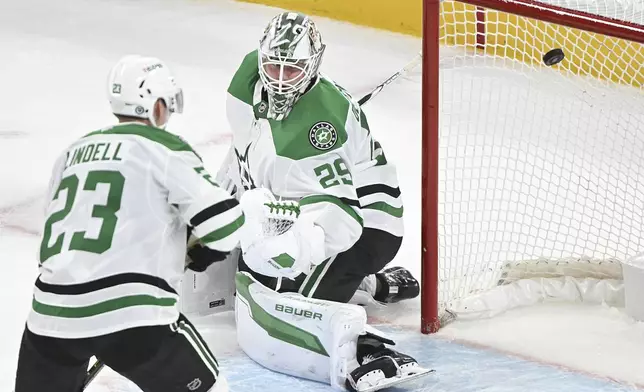 Dallas Stars goaltender Jake Oettinger (29) is scored on by Montreal Canadiens' Patrik Laine (not shown) as Stars' Esa Lindell (23) looks for a rebound during second period NHL hockey action in Montreal, Saturday, Jan. 11, 2025. (Graham Hughes/The Canadian Press via AP)