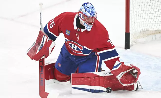 Montreal Canadiens goaltender Jakub Dobes makes a save during warmups ahead of an NHL hockey game against the Dallas Stars in Montreal, Saturday, Jan. 11, 2025. (Graham Hughes/The Canadian Press via AP)