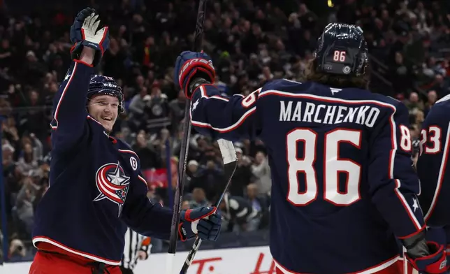 Columbus Blue Jackets' Dmitri Voronkov, left, congratulates Kirill Marchenko on his goal against the St. Louis Blues during the second period of an NHL hockey game Saturday, Jan. 4, 2025, in Columbus, Ohio. (AP Photo/Jay LaPrete)