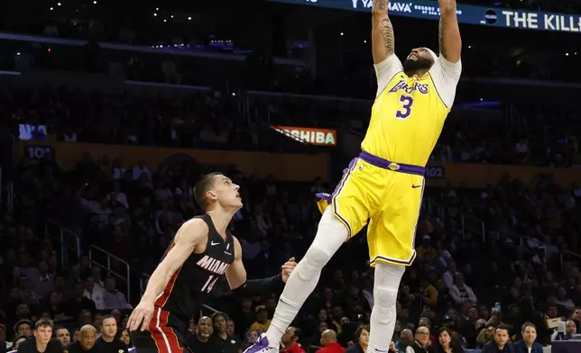 Los Angeles Lakers forward Anthony Davis scores a basket against Miami Heat guard Tyler Herro during the first half of an NBA basketball game Wednesday, Jan. 15, 2025, in Los Angeles. (AP Photo/Kevork Djansezian)