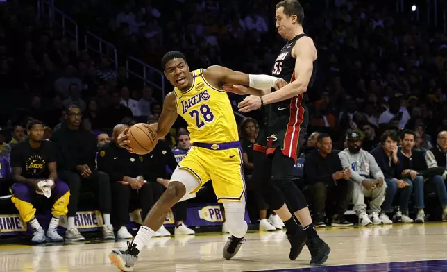 Los Angeles Lakers forward Rui Hachimura is pressured by Miami Heat forward Duncan Robinson during the first half of an NBA basketball game Wednesday, Jan. 15, 2025, in Los Angeles. (AP Photo/Kevork Djansezian)