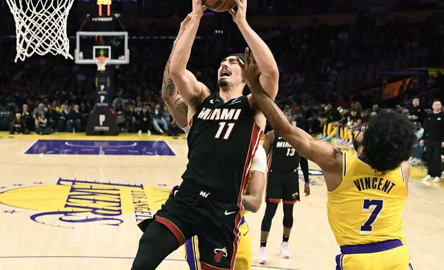 Miami Heat guard Jaime Jaquez Jr. is fouled by Los Angeles Lakers guard Gabe Vincent during the first half of an NBA basketball game Wednesday, Jan. 15, 2025, in Los Angeles. (AP Photo/Kevork Djansezian)