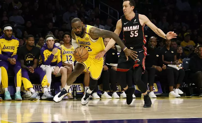 Los Angeles Lakers forward LeBron James drives to the basket against Miami Heat forward Duncan Robinson during the first half of an NBA basketball game, Wednesday, Jan. 15, 2025, in Los Angeles. (AP Photo/Kevork Djansezian)