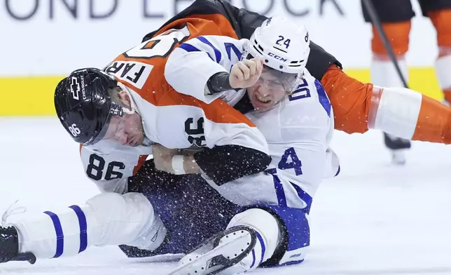 Philadelphia Flyers' Joel Farabee, left, and Toronto Maple Leafs' Connor Dewar fight during the first period of an NHL hockey game, Tuesday, Jan. 7, 2025, in Philadelphia. (AP Photo/Matt Slocum)