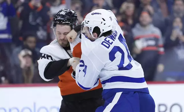 Philadelphia Flyers' Joel Farabee, left, and Toronto Maple Leafs' Connor Dewar fight during the first period of an NHL hockey game, Tuesday, Jan. 7, 2025, in Philadelphia. (AP Photo/Matt Slocum)