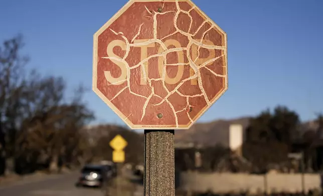 A stop sign is damaged in the aftermath of the Palisades Fire in the Pacific Palisades neighborhood of Los Angeles, Monday, Jan. 13, 2025. (AP Photo/John Locher)