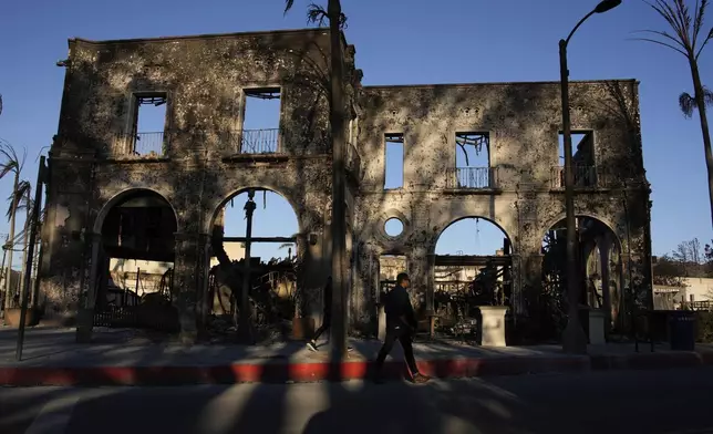 The front face of a building is all that is left standing in the aftermath of the Palisades Fire in the Pacific Palisades neighborhood of Los Angeles, Monday, Jan. 13, 2025. (AP Photo/John Locher)