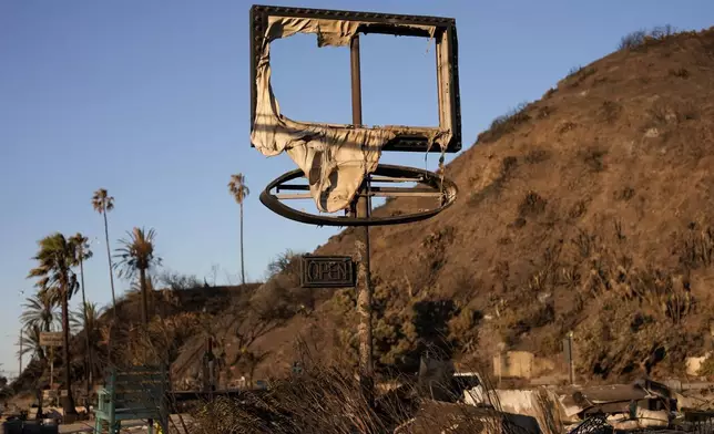 A sign is left behind, damaged by the Palisades Fire Monday, Jan. 13, 2025 in Malibu, Calif. (AP Photo/John Locher)