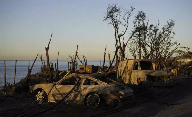 Charred vehicles sit along the coast, Tuesday, Jan. 14, 2025, in Malibu, Calif. (AP Photo/Carolyn Kaster)