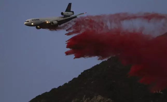 An air tanker drops retardant while battling the Eaton Fire on Monday, Jan. 13, 2025, in Altadena, Calif. (AP Photo/Ty ONeil)