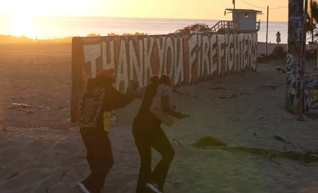 A mural by Sergei Statsenko, who also goes by the artist name Steeke, thanks firefighters in the Venice Beach area of Los Angeles as wildfires burn Monday, Jan. 13, 2025. (AP Photo/Damian Dovarganes)