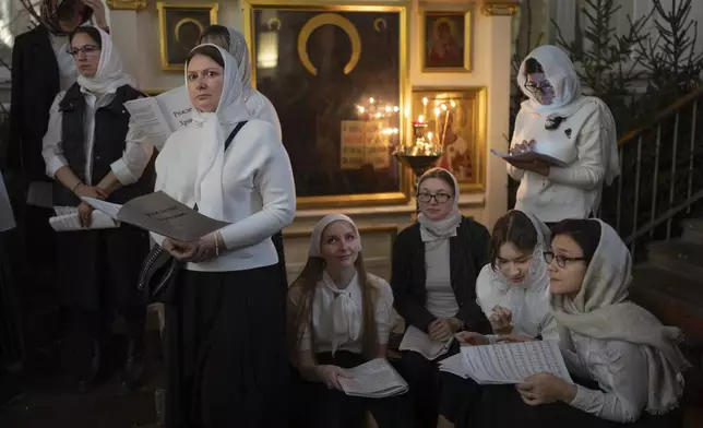 Members of the church choir attend an Orthodox Christmas service at the Church of the Holy Martyr Tatiana near the Kremlin Wall in Moscow, late on Monday, Jan. 6, 2025. (AP Photo/Alexander Zemlianichenko)