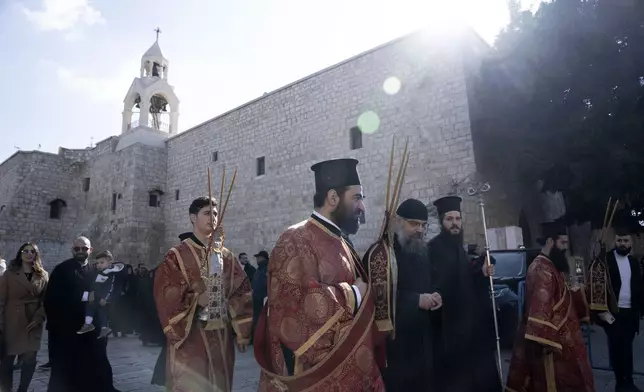 Greek Orthodox clergy walk in procession to receive the Patriarch at the Church of the Nativity, where Christians believe Jesus Christ was born, ahead of Christmas Eve mass in the West Bank city of Bethlehem, Monday, Jan. 6, 2025. (AP Photo/Maya Alleruzzo)