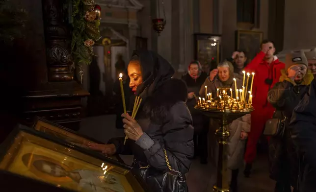 Lithuanian Orthodox believers pray during the liturgy on Orthodox Christmas Eve in the Orthodox Church of the Holy Spirit in Vilnius, Lithuania, Tuesday, Jan. 7, 2025. (AP Photo/Mindaugas Kulbis)